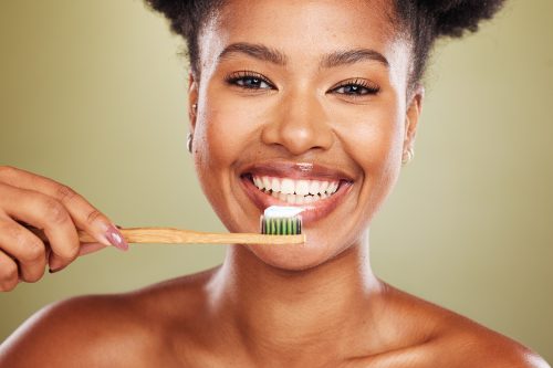 beautiful black woman about to brush teeth with wooden toothbrush
